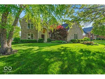 Charming two-story brick home with mature trees and lush green lawn at 5783 Coopers Hawk Dr, Carmel, IN 46033