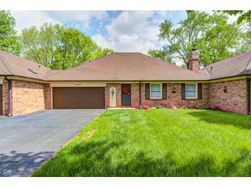 Charming brick home with a well-manicured lawn and attached two-car garage at 6005 Apache Dr, Indianapolis, IN 46254