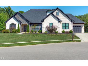 Beautiful home with stone and brick exterior, manicured lawn, black roof, and an attached two-car garage at 8112 Joni Ave, Martinsville, IN 46151