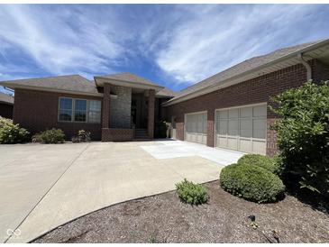 Charming brick home featuring an attached two car garage and an expansive driveway at 888 Westcreek Dr, Columbus, IN 47201