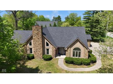 Beautiful home with stone chimney, black roof, and manicured front bushes at 10602 Fall Rd, Fishers, IN 46037