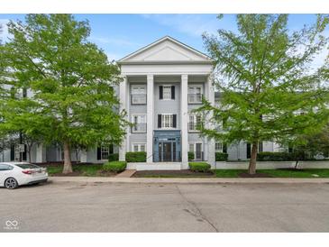 Attractive condo building with large columns and well-maintained landscaping and charming curb appeal at 12833 Tradd St # 1B, Carmel, IN 46032