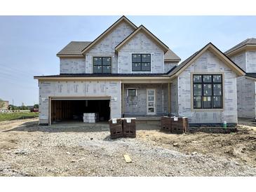 Two-story house featuring a garage, front door, and windows surrounded by construction materials at 1415 Beaumont Cir, Westfield, IN 46074