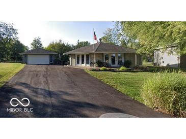 Charming home featuring a stone facade, flag pole, and a detached two car garage at 169 Bayview Dr, Cicero, IN 46034