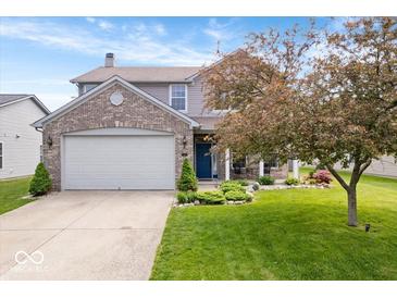 Charming two-story home featuring a well-manicured lawn, a two-car garage, and beautiful landscaping at 1815 Kingen Dr, Greenfield, IN 46140