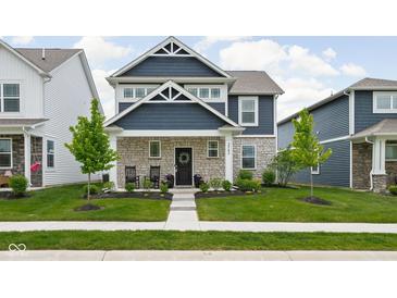 Charming two-story home with blue siding, stone accents, and a well-manicured lawn at 2542 Barstow Dr, Whitestown, IN 46075