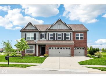 Beautiful two-story home with gray siding, brick accents, a well-manicured lawn, and an attached three-car garage at 4204 Omaha Dr, Bargersville, IN 46106