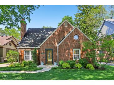 Charming brick home featuring manicured landscaping, a classic chimney, and a quaint, welcoming entrance at 5034 N Capitol Ave, Indianapolis, IN 46208