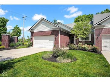 Charming brick home with a well-manicured lawn, lush landscaping, and attached two-car garage at 575 Dylan Dr, Avon, IN 46123