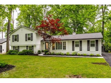 Charming brick and clapboard home with lush landscaping and a well-manicured lawn at 7531 Mohawk Ln, Indianapolis, IN 46260