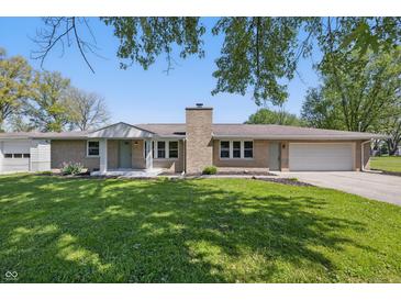 Charming brick ranch home featuring a lush green lawn and attached two-car garage at 1328 Toner Dr, Anderson, IN 46012