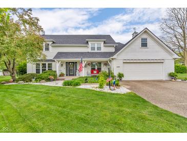 Charming two-story home with a manicured lawn and welcoming front porch adorned with patriotic decor at 14809 Senator Way, Carmel, IN 46032