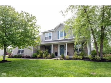 Charming two-story home with well-manicured lawn, featuring brick accents and lush landscaping at 16579 Lakeville Xing, Westfield, IN 46074
