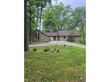 Charming stone house on a sprawling lot with a circular driveway and mature trees at 3692 Whippoorwill Lake S Dr, Monrovia, IN 46157