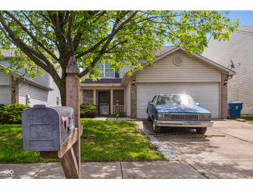 Traditional two-story home featuring a well-maintained lawn, mature trees and a blue car parked in the driveway at 3937 Candle Berry Dr, Indianapolis, IN 46235