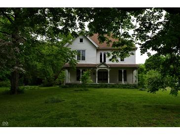 Charming two-story home featuring a welcoming front porch and mature trees in a spacious yard at 4718 W Troy Ave, Indianapolis, IN 46241