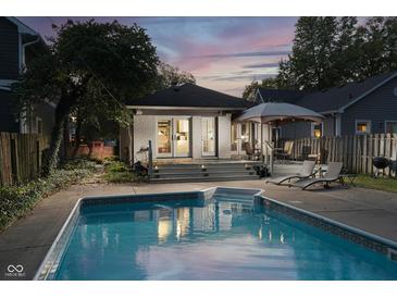 Inviting backyard pool and deck area with lounge chairs and a covered dining space, perfect for outdoor entertaining at 6167 Carrollton Ave, Indianapolis, IN 46220