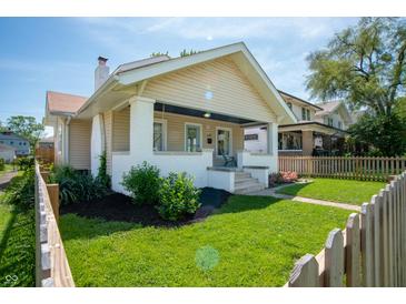 Charming craftsman-style home featuring a covered porch, manicured lawn, and attractive landscaping at 625 Dequincy St, Indianapolis, IN 46201