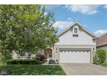 Charming home featuring a two-car garage, landscaped yard, and beautiful brick accents at 9760 Innisbrook Blvd, Carmel, IN 46032