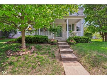 Charming home featuring a welcoming front porch, landscaped yard, and beautiful curb appeal at 13063 E 131St St, Fishers, IN 46037