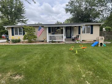 Charming single-story home featuring a well-maintained lawn, landscaping, and a welcoming front porch at 1505 Apple St, Greenfield, IN 46140