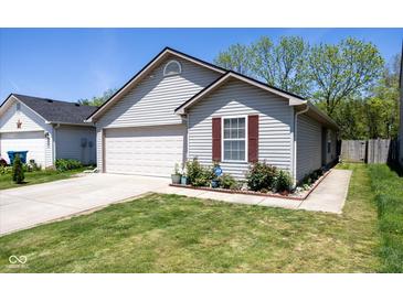 Charming single-story home featuring a well-manicured lawn, attached garage, and delightful curb appeal at 320 Red Tail Ln, Indianapolis, IN 46241