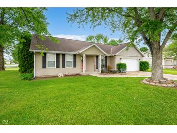 Lovely home featuring mature trees, manicured lawn, an attached garage and welcoming front porch at 3334 Old Field Ln, Columbus, IN 47203