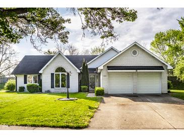 Charming brick home with a well-manicured lawn, arched window, and an attached two-car garage at 51 Glasgow Ln, Noblesville, IN 46060