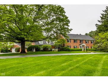 Brick home with lush green lawn and mature trees creates a charming curb appeal at 5356 S U.S. Highway 421, Zionsville, IN 46077