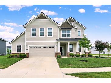 Charming two-story home features a well-manicured lawn, attached garage, and inviting front porch with white pillars at 5366 Laurel Crest Run, Noblesville, IN 46062