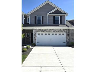 Two-story home featuring a gray exterior, brick accents, and a two-car garage at 6403 Yuma Ct, Whitestown, IN 46075