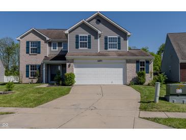 Two-story home with a brick and vinyl facade, blue shutters, a two-car garage, and a well-manicured lawn at 6491 Enclave Blvd, Greenwood, IN 46143