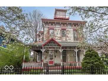Charming Victorian-style home featuring a classic front porch, red trim and distinctive architectural details at 866 Fletcher Ave, Indianapolis, IN 46203