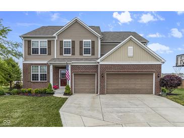 Charming two-story home featuring brick and siding, a well-manicured lawn, and an attached two-car garage at 952 Workington Cir, Westfield, IN 46074