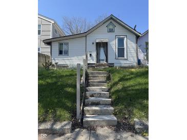 Charming home featuring a quaint facade, concrete steps, and green lawn, ready for renovation and landscaping at 1314 Laurel St, Indianapolis, IN 46203