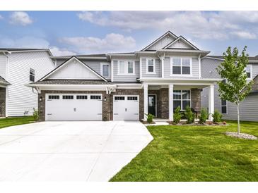 Charming two-story home featuring a three-car garage, brick accents, and a well-manicured lawn at 19442 Honeylocust Glen, Noblesville, IN 46062