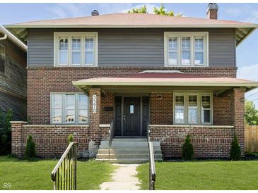 Charming brick two-story home with a well-manicured lawn and classic architectural details at 3370 N New Jersey St, Indianapolis, IN 46205