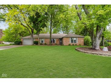 Charming red brick ranch home featuring a spacious green lawn and mature trees at 3698 E 106Th St, Carmel, IN 46033