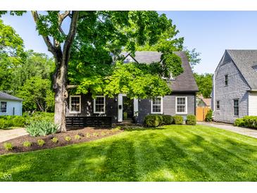 Charming house with a well-maintained lawn, lush tree, and classic architectural details at 5280 N Capitol Ave, Indianapolis, IN 46208