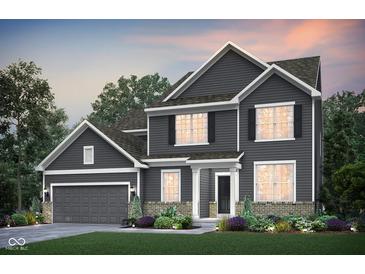 Charming two-story home boasts gray siding, a manicured lawn, and complemented by lush landscaping at 591 Dalton Way, Avon, IN 46123