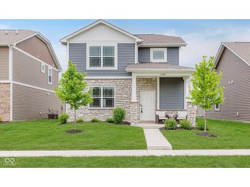Charming two-story home featuring stone accents, blue siding, a well-manicured lawn, and sidewalk at 6460 Wasco Dr, Whitestown, IN 46075