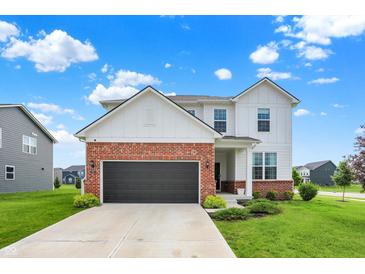 Charming two-story home featuring a brick and white exterior with a well-manicured lawn and attached two-car garage at 6843 Black Cherry Ter, Brownsburg, IN 46112
