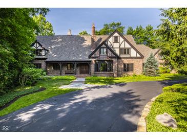 Charming Tudor home with a landscaped front yard and a circular driveway at 7406 N Washington Blvd, Indianapolis, IN 46240