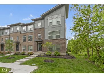 Modern townhome showcasing a stylish brick and siding facade, professional landscaping, and inviting entrance at 8245 Bostic Dr, Fishers, IN 46038