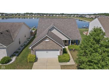 Charming brick home boasts a well-manicured lawn and a tranquil lake view, enhancing its curb appeal at 8644 S Tibbs Ave, Indianapolis, IN 46217