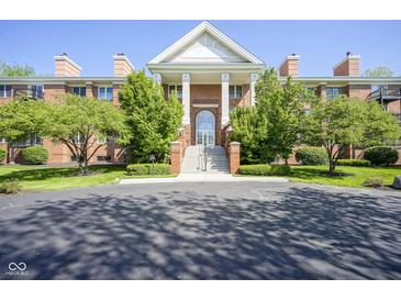 Elegant brick building with a grand entrance featuring white columns and manicured landscaping at 8751 Jaffa Court East Dr # Apt 32, Indianapolis, IN 46260