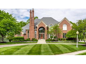 Beautiful brick home with manicured lawn, arched windows, and a welcoming entrance at 10554 Hyde Park, Carmel, IN 46032