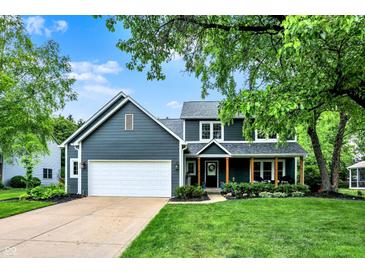 Charming two-story home featuring a covered front porch, a spacious lawn, and an attached two-car garage at 10906 Camden Ct, Fishers, IN 46038