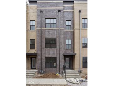 Newly constructed townhome with brick facade and multiple windows, awaiting final landscaping at 1216 N Alabama St, Indianapolis, IN 46202