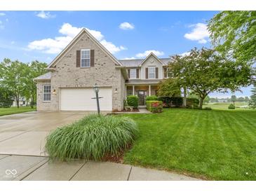 Charming two-story home with a well-manicured lawn, attached garage, and beautiful landscaping at 18711 Crestline Ct, Noblesville, IN 46060